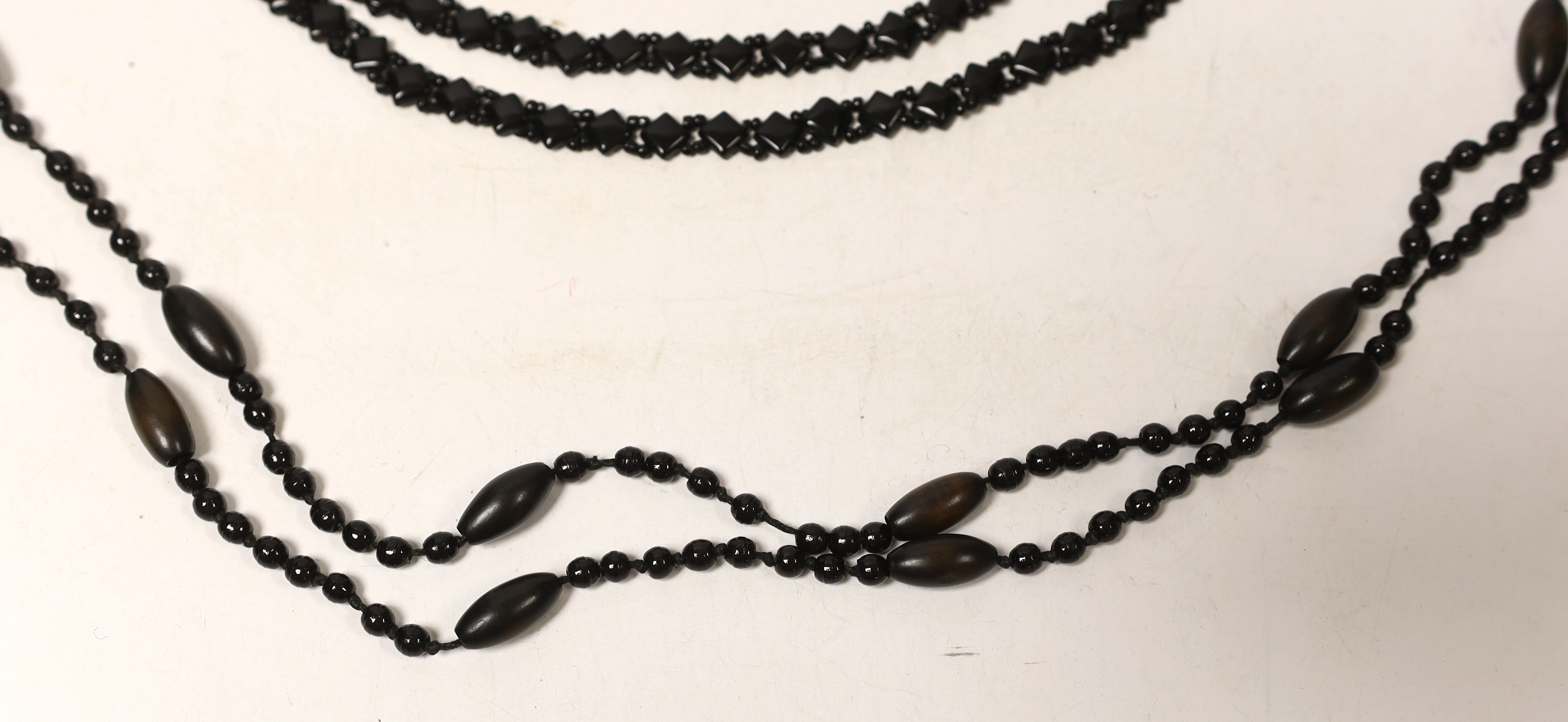 Three assorted necklaces including Whitby jet, largest 162cm.